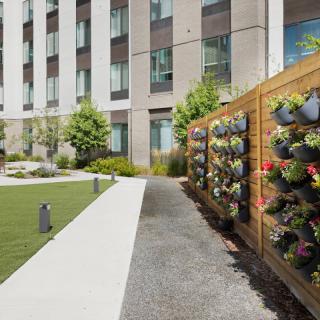A modern apartment complex featuring a beautifully landscaped outdoor space with a vertical garden.