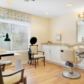 A well-lit, modern beauty salon with stylish chairs and a large mirror.