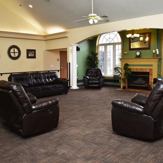A cozy living room with leather couches and a fireplace.