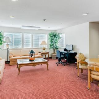 A spacious lobby with seating, computer desks, and indoor plants.