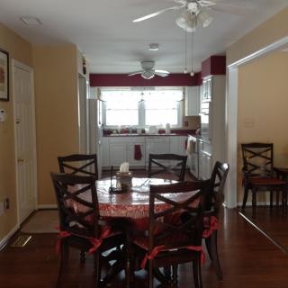 A cozy dining area with a table and chairs, leading into a kitchen.