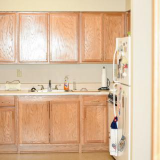 A clean kitchen with wooden cabinets and a refrigerator.
