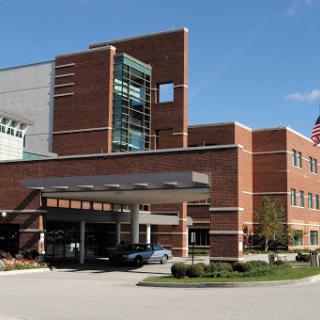 A modern hospital building featuring a blend of brick and glass architecture.