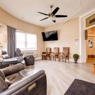 A cozy living room with leather recliners, a ceiling fan, and a wall-mounted TV.
