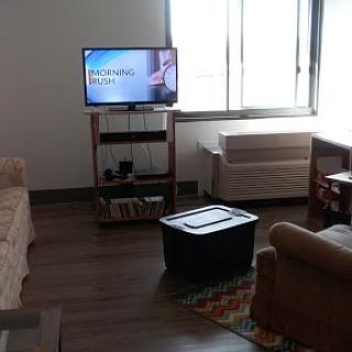 A cozy living room featuring a TV, sofa, and a coffee table.