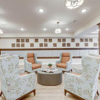 A modern seating area with patterned chairs and a central table, illuminated by overhead lighting.
