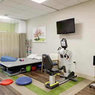 A physical therapy room equipped with various rehabilitation tools and a treatment table.