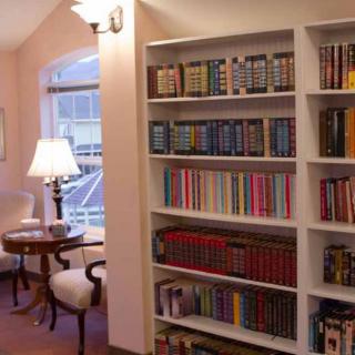 A cozy reading nook with a well-stocked bookshelf and comfortable seating.