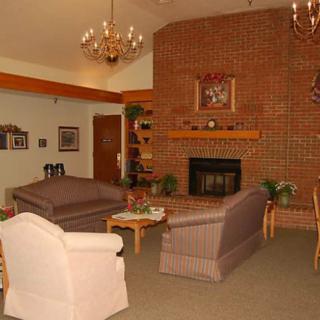 Cozy living room with a brick fireplace and elegant chandeliers.