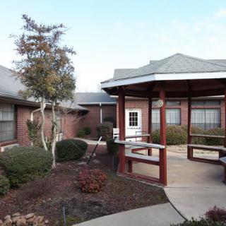 A well-maintained courtyard features a gazebo and landscaped garden, surrounded by buildings.