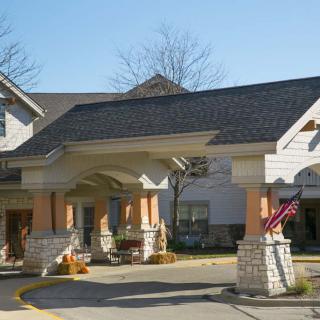 The image shows the entrance of a residential building on a sunny day.