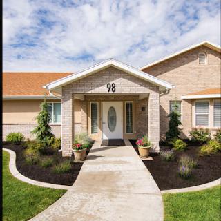 A charming brick house with a welcoming entrance and well-maintained landscaping.