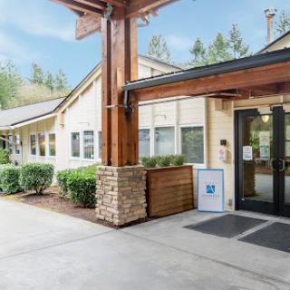 Welcoming entrance to a modern building surrounded by greenery.