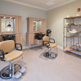 An empty hair salon with styling chairs and mirrors.