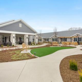 A modern building with a landscaped garden and pathway.
