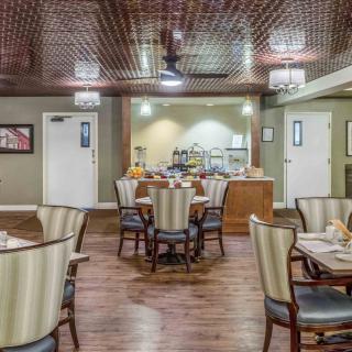 A stylish dining room with elegantly arranged tables and chairs, featuring a wooden floor and decorative ceiling.