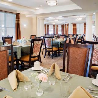 An elegant restaurant dining room with neatly set tables and comfortable chairs.