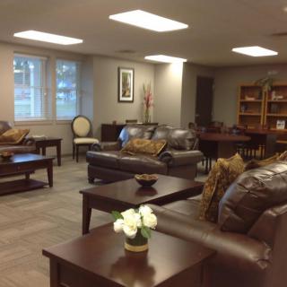 A cozy living room with leather sofas and bookshelves.