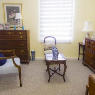 A traditionally decorated living room with wooden furniture and a window letting in natural light.