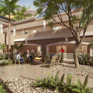 A peaceful courtyard with people relaxing and enjoying the outdoor seating surrounded by trees and plants.