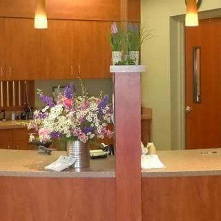 A modern office reception desk adorned with a bouquet of flowers.