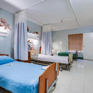 A clean and organized hospital patient room with multiple beds.