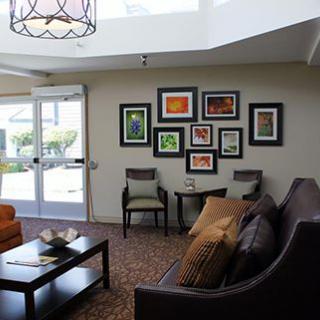 A modern living room featuring a seating area with sofas and chairs,
 complemented by a coffee table and a wall adorned with colorful artwork.
