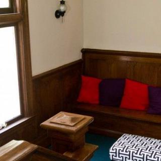 Cozy corner with wood-paneled seating and colorful cushions.
