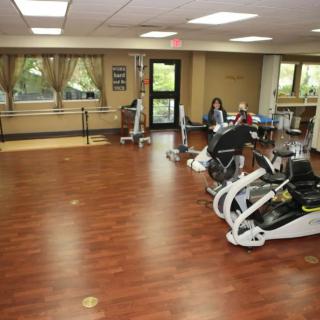 A rehabilitation center therapy room equipped with exercise machines and therapeutic tools.