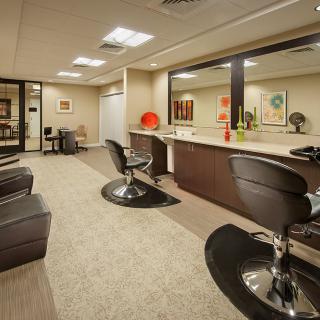 A modern salon interior with styling chairs and large mirrors.