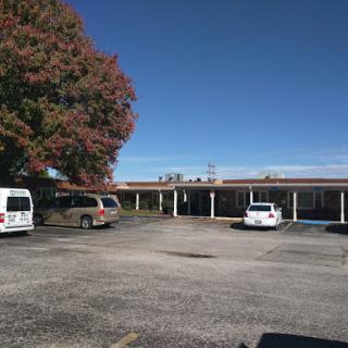 A view of a building with a parking lot and clear blue sky.