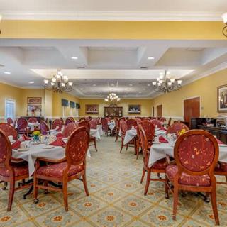A spacious and elegantly decorated dining room with neatly arranged tables and chairs.