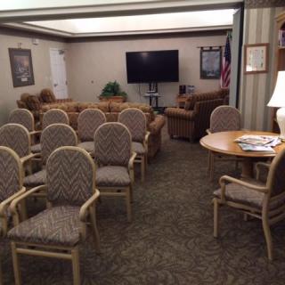 A conference room with arranged seating and a television for meetings.