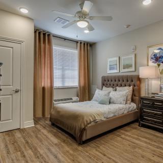 A modern bedroom with sleek furnishings and warm lighting.