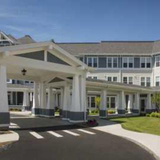 A beautifully designed building with a grand entrance and well-maintained landscaping.