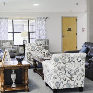 A cozy living room with patterned chairs, sofas, and a wooden table.