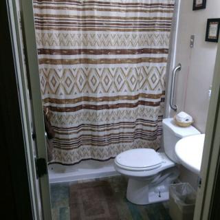 A small bathroom with a patterned shower curtain and basic amenities.