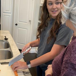 A young woman and an older woman in the kitchen, preparing food together.