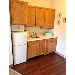 A compact kitchen with wooden cabinets and essential appliances.