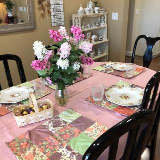 A beautifully set dining table with floral arrangements and decorative place settings.