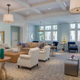 A spacious and elegantly designed living room with comfortable seating, large windows, and tasteful decor.