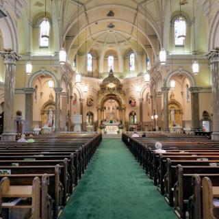A serene interior view of a church, showcasing its elegant architecture and arrangement of pews leading to the altar.