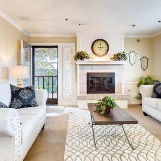 A cozy and elegantly decorated living room featuring a fireplace, comfortable sofas, a modern coffee table, and tasteful decor.