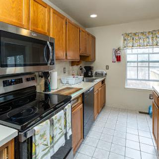 A warm and functional kitchen featuring wooden cabinetry, modern appliances, and natural light.