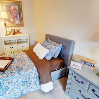 A cozy bedroom with a neatly made bed, nightstands, and decorative elements.