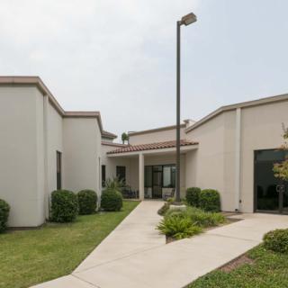 A modern building exterior with a landscaped walkway.