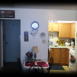 A cozy kitchen and dining area with a small table, chairs, and wall decor.