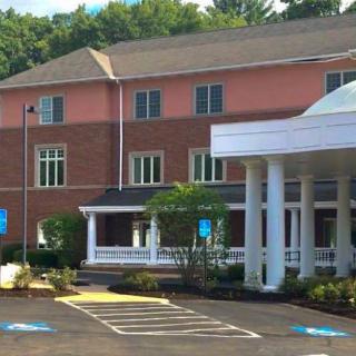 A building with a columned entrance and a parking lot featuring accessible spaces.