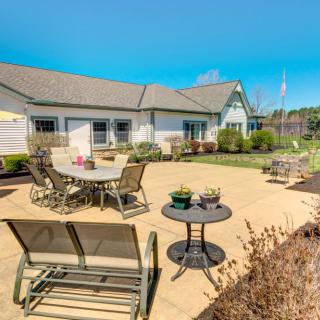 A sunny outdoor patio area with furniture and landscaped gardens.