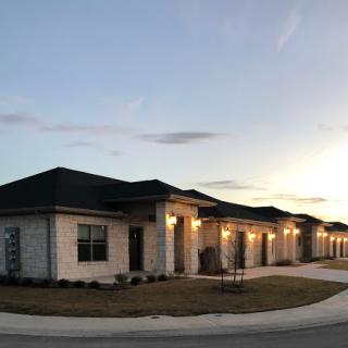 A row of modern suburban houses illuminated at dusk.